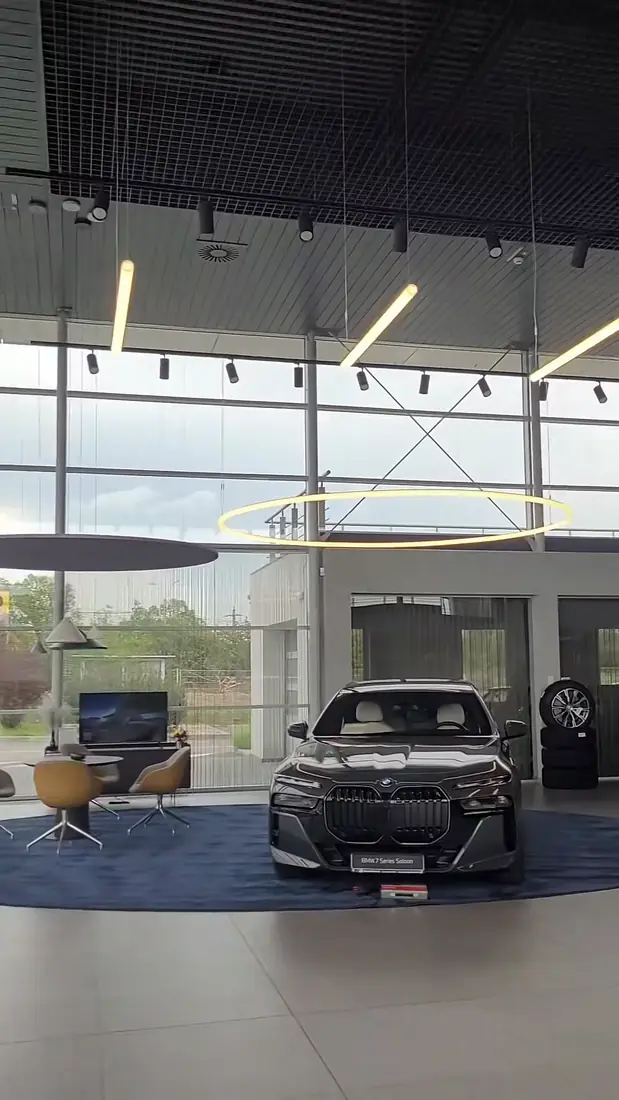 Showroom-ul BMW cu mașina expusă și peretele de sticlă curat